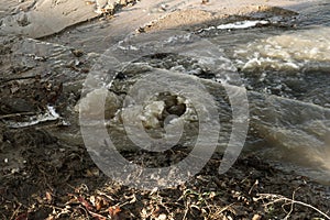 Emergency Sewerage. Water flows down the sidewalk from a ruptured underground sewer pipe. The accident of the city water supply. A