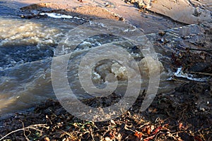 Emergency Sewerage. Water flows down the sidewalk from a ruptured underground sewer pipe. The accident of the city water supply. A