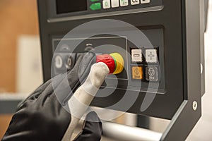 Emergency shutdown button in production. The CNC operator presses the emergency button on the control panel of the CNC