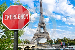 Emergency sign on Eiffel tower in Paris background. Financial crash in world economy because of coronavirus. Global economic