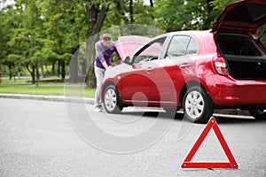 Emergency stop sign and man near broken car