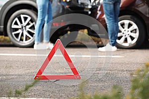 Emergency stop sign near people discussing car accident on road