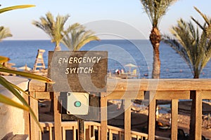 emergency switch button on the beach background of blue sea and palm trees