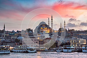 Eminonu Pier on a sunset on Golden Horn with a view of the Historic Suleymaniye Mosque on Hill in Istanbul Old City, Turkey