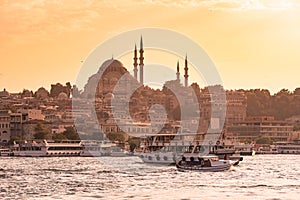 Eminonu Port with Ships and Suleymaniye Mosque in the Fatih district at Golden Horn River before sunset, Istanbul, Turkey. Travel