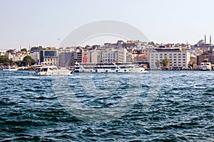 Eminonu shorescape and passenger ferry and yachts surfing photo