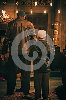 EminÃÂ¶nÃÂ¼, Istanbul / Turkey - 02 07 2014: Muslim men and child praying in Yeni Cami New Mosque interior