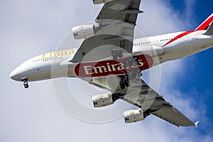 An Emirates airlines plane flying in the sky with blue sky and clouds in Inglewood California