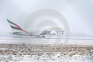 Emirates Airlines A380 taking off from snowy runway