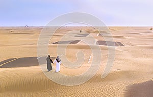 Emirati couple on a sandy road near Dubai