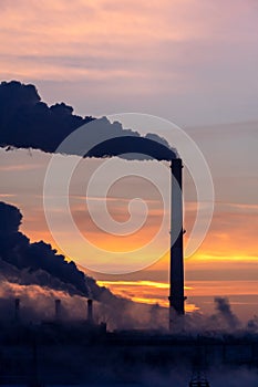 Emission to atmosphere from industrial pipes. Smokestack pipes shooted at sunrise