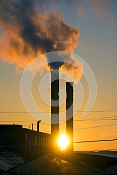 Emissions from plant pipe against setting sun