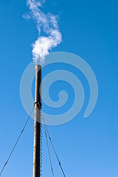 Emitting white smoke old metal chimney