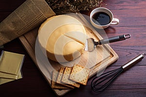 Emmental cheese cake with coffee and biscuit on wooden table