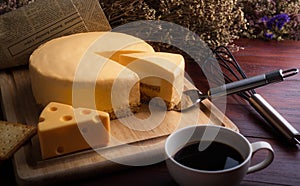 Emmental cheese cake with coffee and biscuit on wooden table