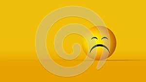 Emoji face with an expression of sadness on yellow background with copyspace