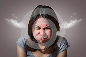 Emotion concept, Portrait of angry cute asian woman posing looking at camera with grey clothes on gray background