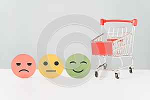 Emotion face on circle paper cut and red shopping cart for positive thinking ,customer review, experience, satisfaction survey