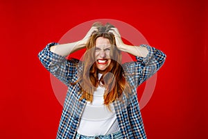 Emotion and people concept. Emotional angry 30s woman screaming on red studio background. Screaming, hate, rage