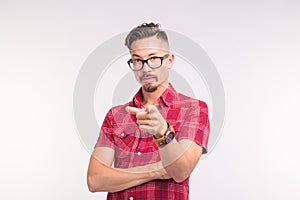 Emotion, people and gesture concept - young handsome man pointing on you on white background