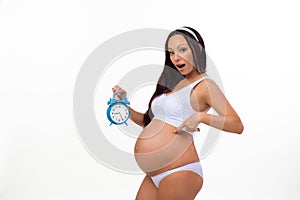 Emotion photo pregnant woman with alarm clock. Surprise. Pregnancy.