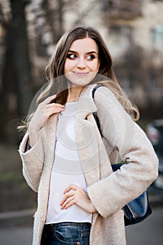 Emotion portrait of smiling happy woman in beige coat.