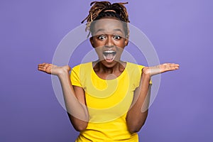 Emotional african american female expressing amazement over purple background