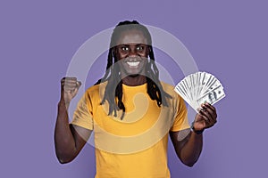 Emotional african american guy showing cash dollars and gesturing