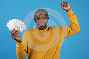 Emotional african american man showing cash and gesturing