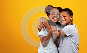 Emotional african american brother and sister embracing and smiling