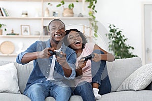 Emotional african family playing video games at living room