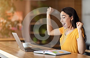 Emotional arab girl got job, shouting in front of laptop