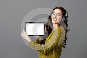 Emotional, attractive young woman showing tablet computer with empty touch screen with copy space