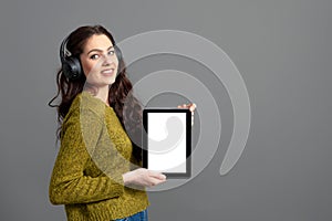 Emotional, attractive young woman showing tablet computer with empty touch screen with copy space