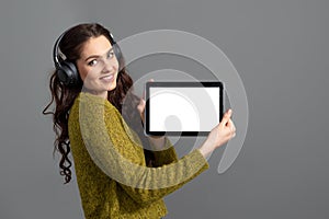 Emotional, attractive young woman showing tablet computer with empty touch screen with copy space