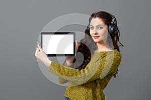 Emotional, attractive young woman showing tablet computer with empty touch screen with copy space