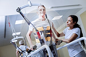 Emotional baby boomer wearing a rehabilitation body vest and smiling