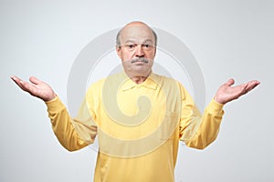 Emotional bearded man not sure for something. Studio shot, gray background