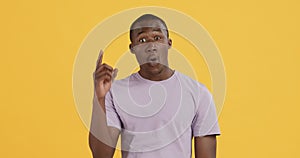 Emotional black guy having idea, pointing finger up