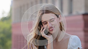 Emotional blonde blue-eyed millennial lady share amazing news with friend by phone hold device by ear. Surprised young