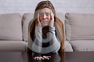 Emotional breakdown and suicide. Young lady with pills having psychological disorder and planning to kill herself