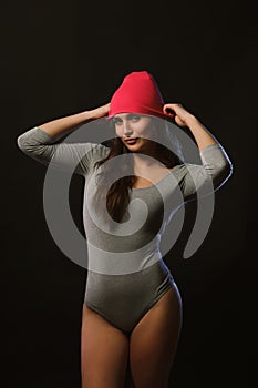 Emotional brunette girl posing in studio during model tests dressed in grey underwear and cap