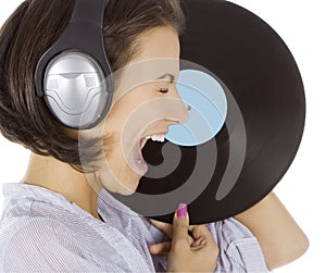 Emotional brunette in headphones with vinyl record ov