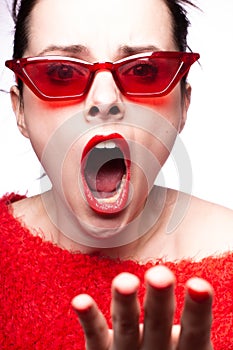 emotional brunette woman in red sunglasses, red nails, red lipstick, white background