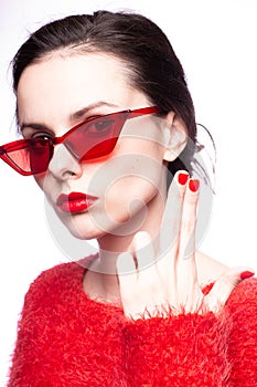 emotional brunette woman in red sunglasses, red nails, red lipstick, white background