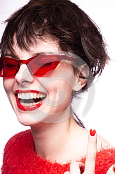 emotional brunette woman in red sunglasses, red nails, red lipstick, white background