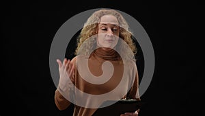 Emotional Caucasian woman talking gesturing standing at black background. Portrait of agitated female speaker presenting