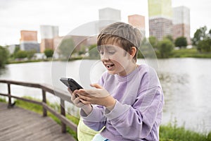 emotional child plays games on the phone, communicates with friends online, watches streams.