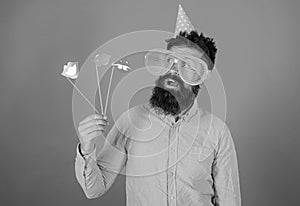 Emotional diversity concept. Guy in party hat celebrate, posing with photo props. Hipster in giant sunglasses