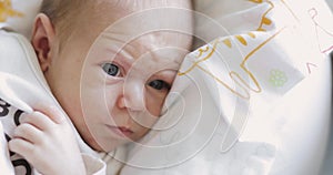 Emotional face with wrinkles on forehead of tiny newborn baby.